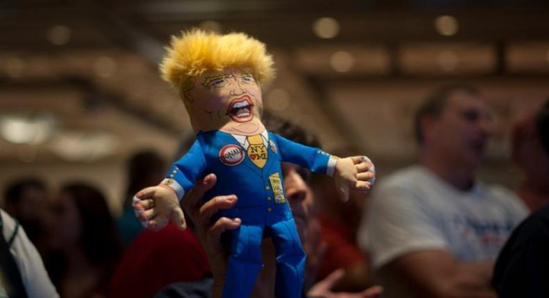 A supporter of Republican presidential candidate Donald Trump holds up a Trump doll during an election night party at a hotel in downtown Phoenix, Arizona