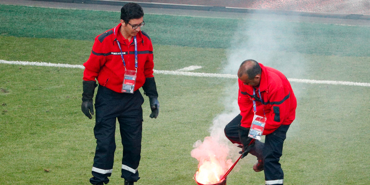 Stewards extinguish a flare in Saint Etienne during a stoppage in the Croatia-Czech Republic match at Euro 2016