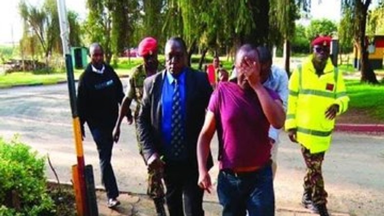 Major Peter Mugure being arrested by military police officers