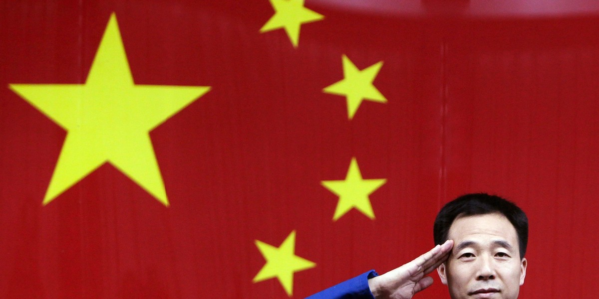 Chinese astronaut Jing Haipeng salutes during a news conference at Jiuquan Satellite Launch Center, in northwest China's Gansu province.