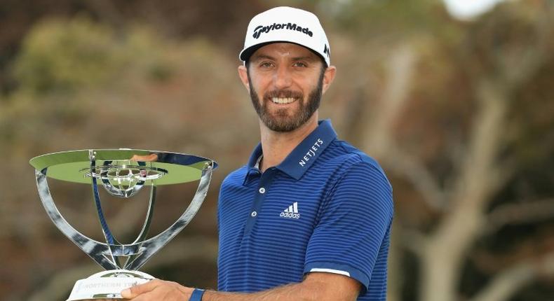 Dustin Johnson of the US poses with the trophy after putting for birdie on the 18th green to defeat compatriot Jordan Spieth in a playoff to win The Northern Trust, at Glen Oaks Club in Westbury, New York, on August 27, 2017