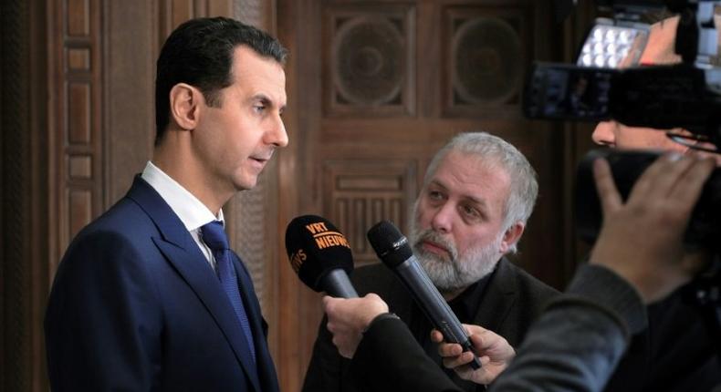 Syrian President Bashar al-Assad (left) speaks to foreign reporters in Damascus, on February 7, 2017