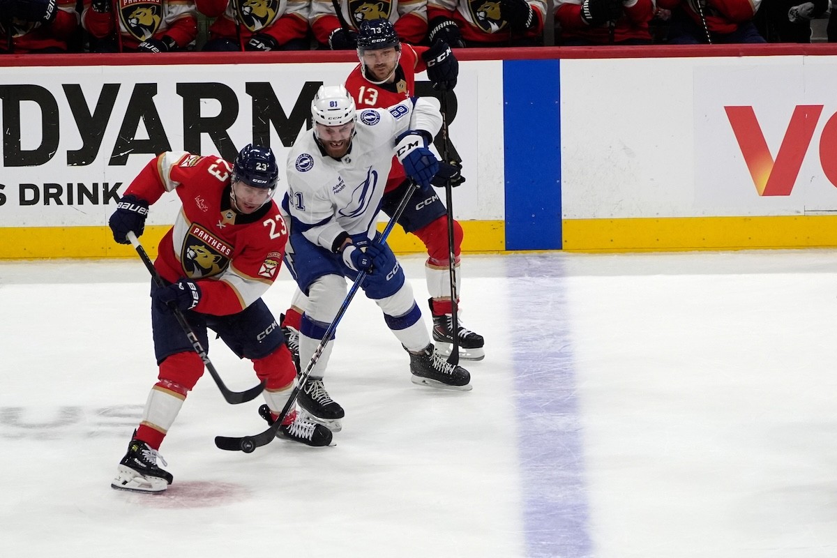 Slovenský hokejista Erik Černák (Tampa Bay Lightning) bojuje o puk s hráčmi Floridy Panthers.