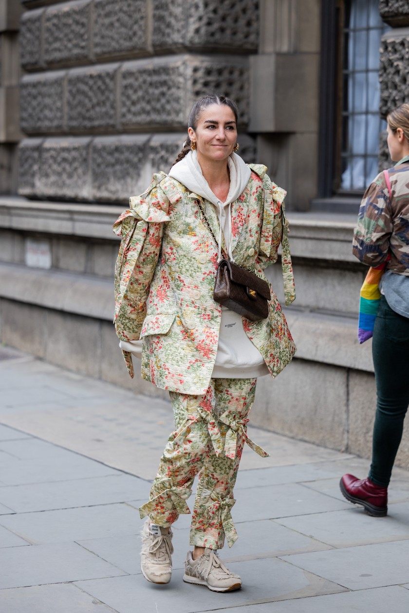 Eine Besucherin der London Fashion Week im floralen Set, das sie lässig mit Hoddie und Sneakern stylt, am 18. September vor der Simone-Rocha-Show.