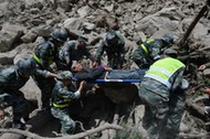 Chinese paramilitary police carry a survivor after an earthquake in Jiuzhaigou county