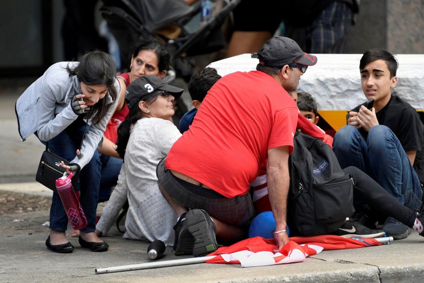 A crowd of people and police attend to the injured following a shooting during a victory celebration