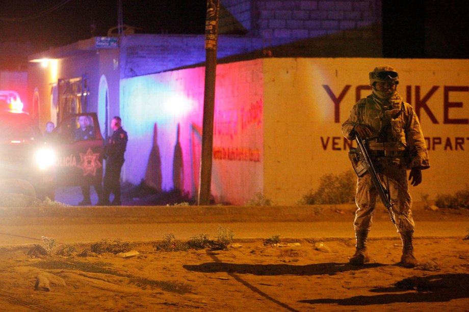 Federal forces keep watch at a crime scene where three men were gunned down by unknown assailants in Ciudad Juarez, Mexico, September 27, 2016.