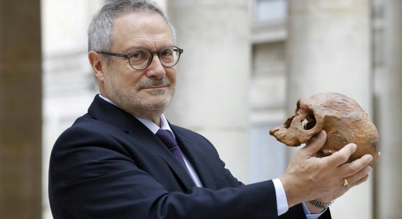 French paleoanthropologist Jean-Jacques Hublin poses with the casting of a Homo Sapiens skull discovered in Morocco. The human species roamed Africa 300,000 years ago, according to new research that pushes back human origins by 100,000 years.