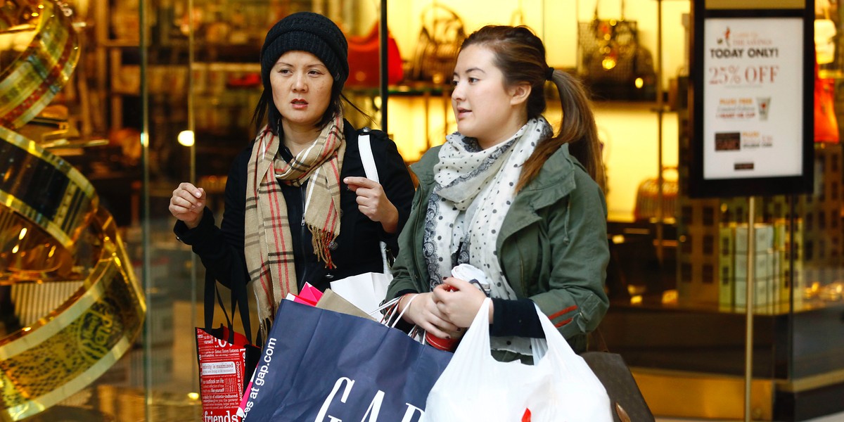 Shoppers walk with bags at Somerset Collection shopping mall in Troy, Michigan.