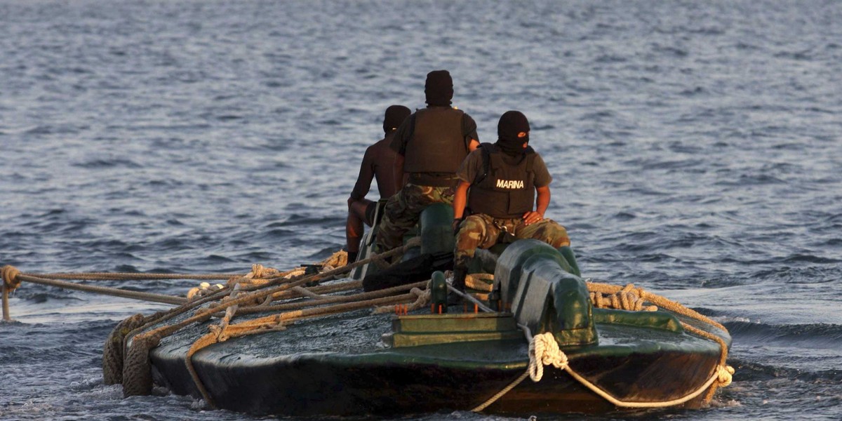 Navy sailors ride atop a 10-meter submarine packed with 5.8 tons of cocaine, as it is being towed into the port of Salina Cruz, Mexico, Friday, July 18, 2008.