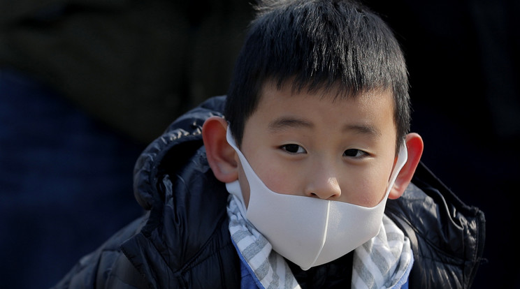 Védőmaszkot viselő kisfiú a pekingi vasútállomáson 2020. január 25-én, a kínai holdújév első napján. Fotó: MTI/EPA