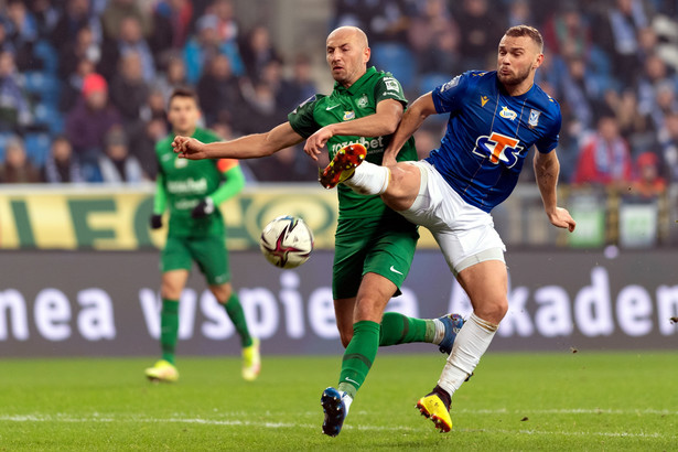 Piłkarz drużyny Lech Poznań Jesper Karlstroem (P) i Łukasz Trałka (L) z zespołu Warta Poznań podczas meczu Ekstraklasy, na Stadionie Miejskim