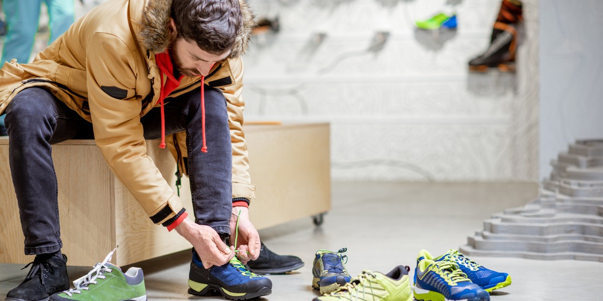 Man trying shoes for hiking in the shop