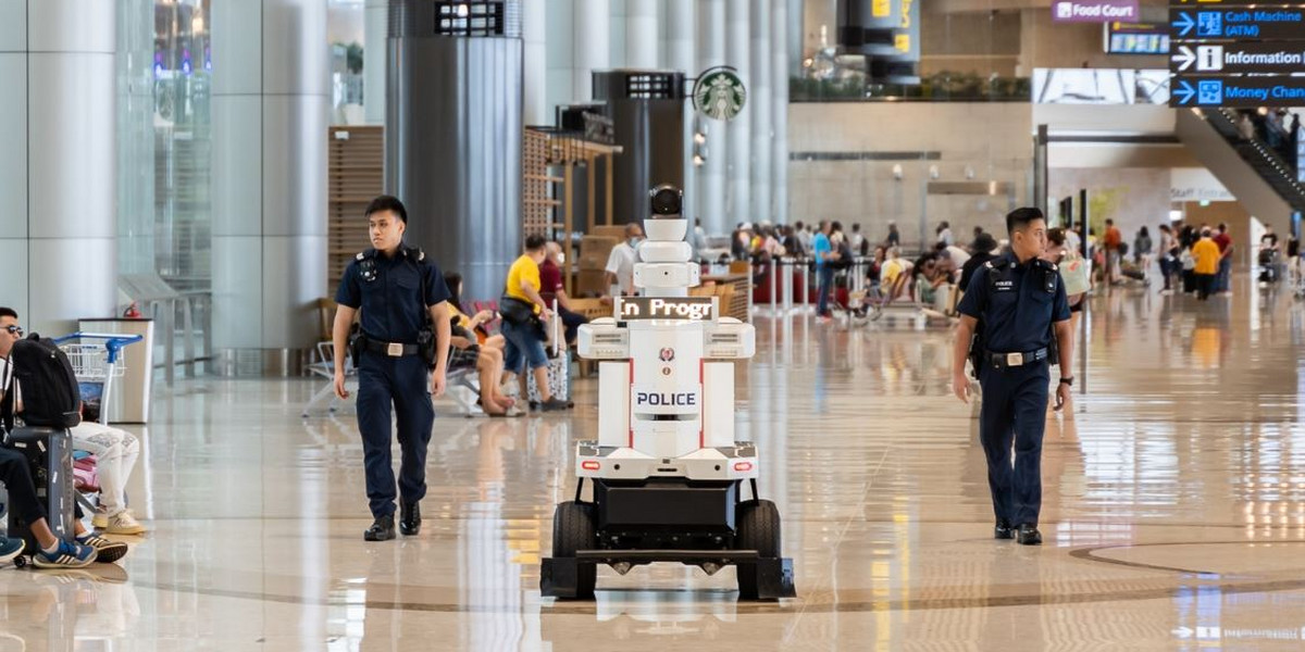 Robot wraz z funkcjonariuszami patroluje lotnisko.