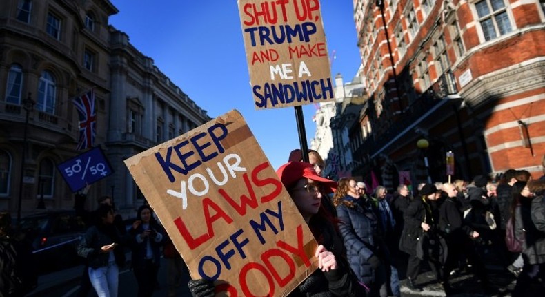 Protesters hold placards during the Women's March in London on January 21, 2017 as part of a global day of protests against new US President Donald Trump