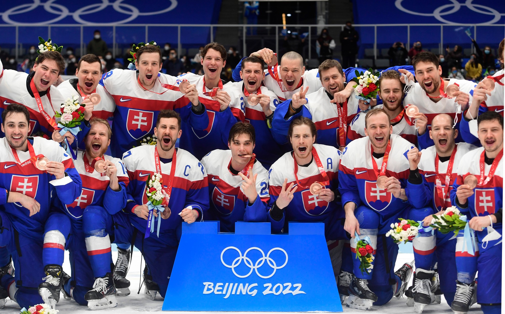Slovenskí hráči pózujú s bronzovými medailami po zápase olympijského turnaja v hokeji mužov o bronz Slovensko - Švédsko na ZOH 2022 v Pekingu.
