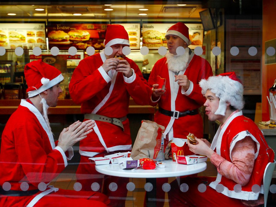 Men wearing Father Christmas outfits eat in a fast food restaurant in central London December 12, 2009.