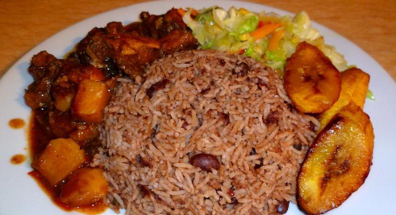 Waakye with chicken stew, fried plantain and steamed cabbage