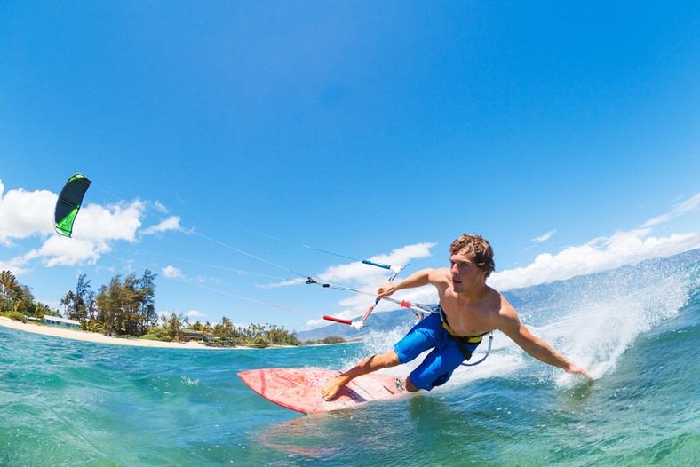 <b>Kitesurfing</b>
<br></br>
Kitesurfing to jeszcze dość młoda odmiana surfingu. Jej odmienność od windsurfingu polega na tym, że zamiast żaglem pęd uzyskujemy tutaj latawcem. W tej dyscyplinie wyposażenie składa się głównie z trzech elementów: deski, latawca oraz baru, czyli zestawu lin i elementów, które łączą kitesurfera z latawcem. Do uprawiania kitesurfingu nadają się m.in. wody przybrzeżne Bałtyku. Technika prowadzenia deski w kitesurfingu jest nieco podobna do prowadzenia deski snowboardowej po śniegu; w obu przypadkach poruszamy się na krawędzi.