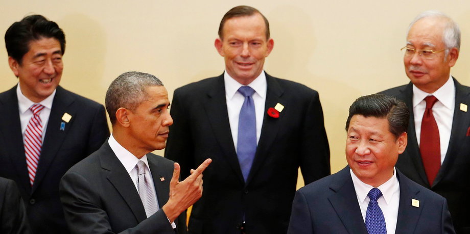 US President Barack Obama next to China's President Xi Jinping in front of Japan's Prime Minister Shinzo Abe, back right, Australia's Prime Minister Tony Abbott, back center, and Malaysia's Prime Minister Najib Razak at a photo shoot for the Asia Pacific Economic Cooperation (APEC) leaders' meeting in Beijing, November 11, 2014.