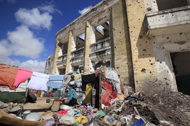 An internally displaced woman stands next to her makeshift tent in the Bondhere area of Mogadishu Oc