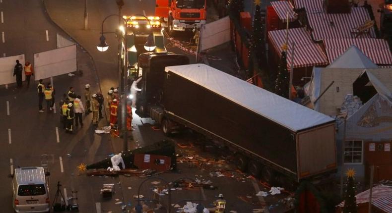 Forensic experts examine the scene around a truck that crashed into a Christmas market on December 20, 2016 in Berlin