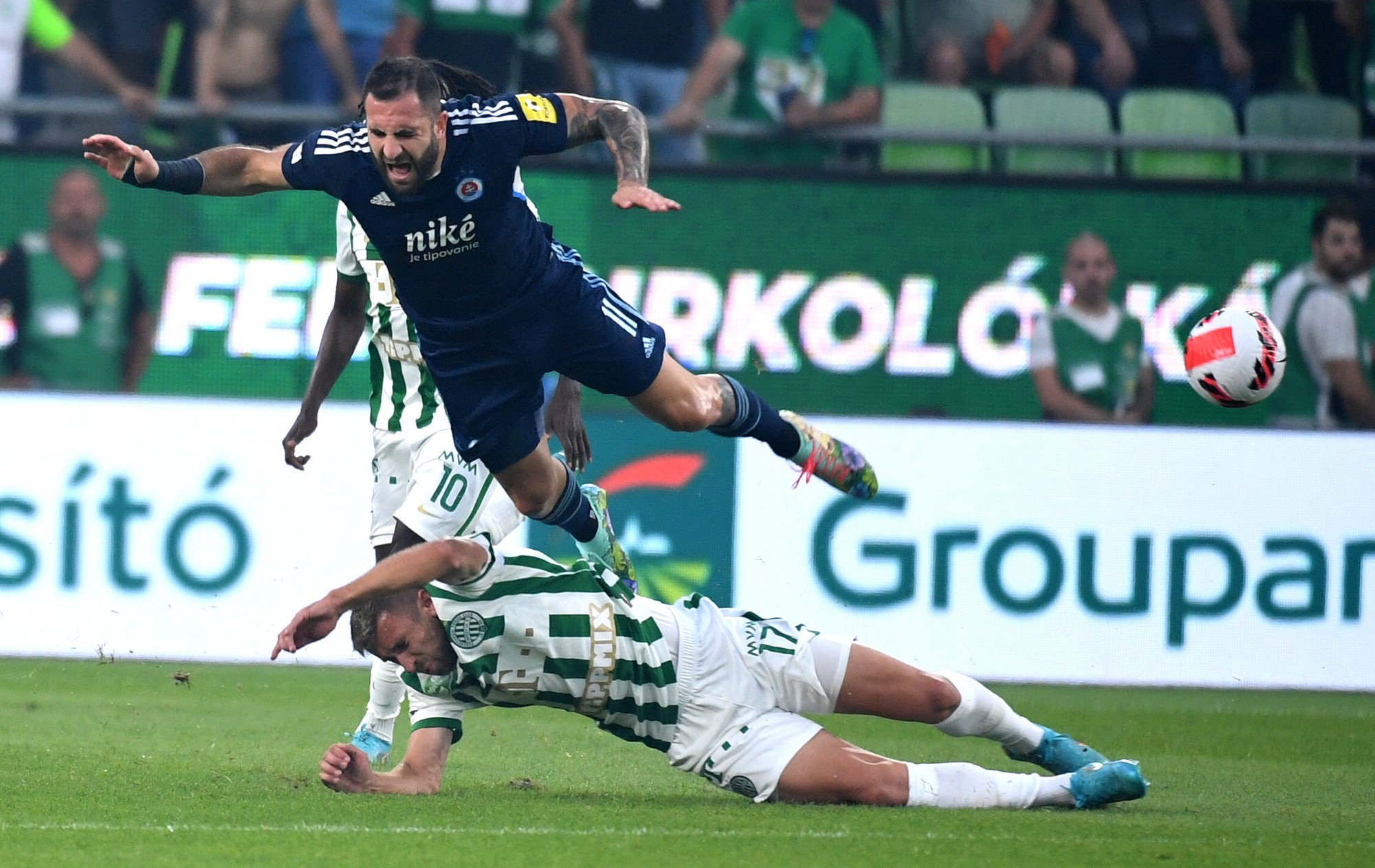 Futbalista Slovana Tigran Barseghyan (hore) a hráč Ferencvárosu Budapešť Eldar Čivič bojujú o loptu.