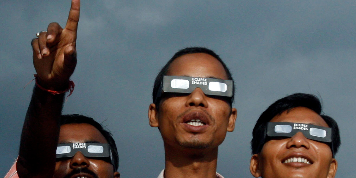 People watch the solar eclipse at Dhulia Gach village, India