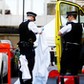 Police officers unfold a sheet infront of a body covered with a blanket after the London Ambulance Service reported that a man collapsed and died from a heart attack in the Mayfair district of central London