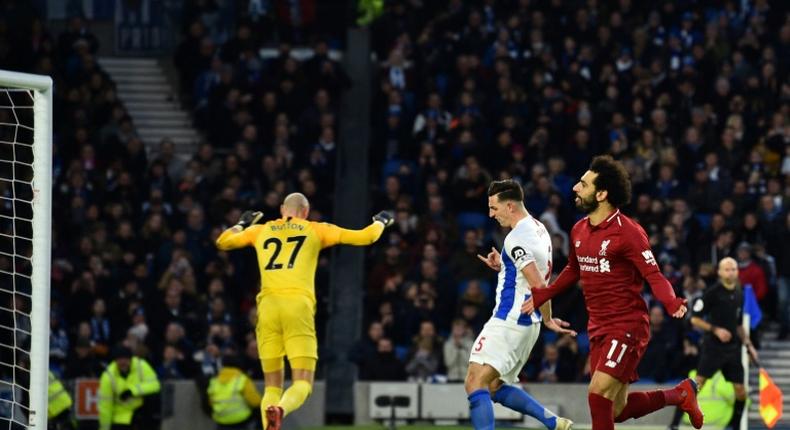 Mohamed Salah (R) celebrates after scoring from the decisive penalty in Liverpool's 1-0 win away to Brighton on Saturday