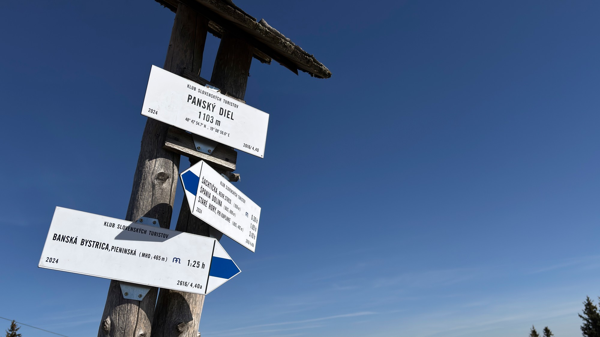 Turistický smerovník na vrchole kopca Panský diel nad Banskou Bystrcou počas slnečného jesenného dňa