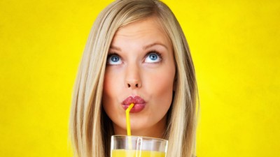 Thoughtful woman sipping orange juice