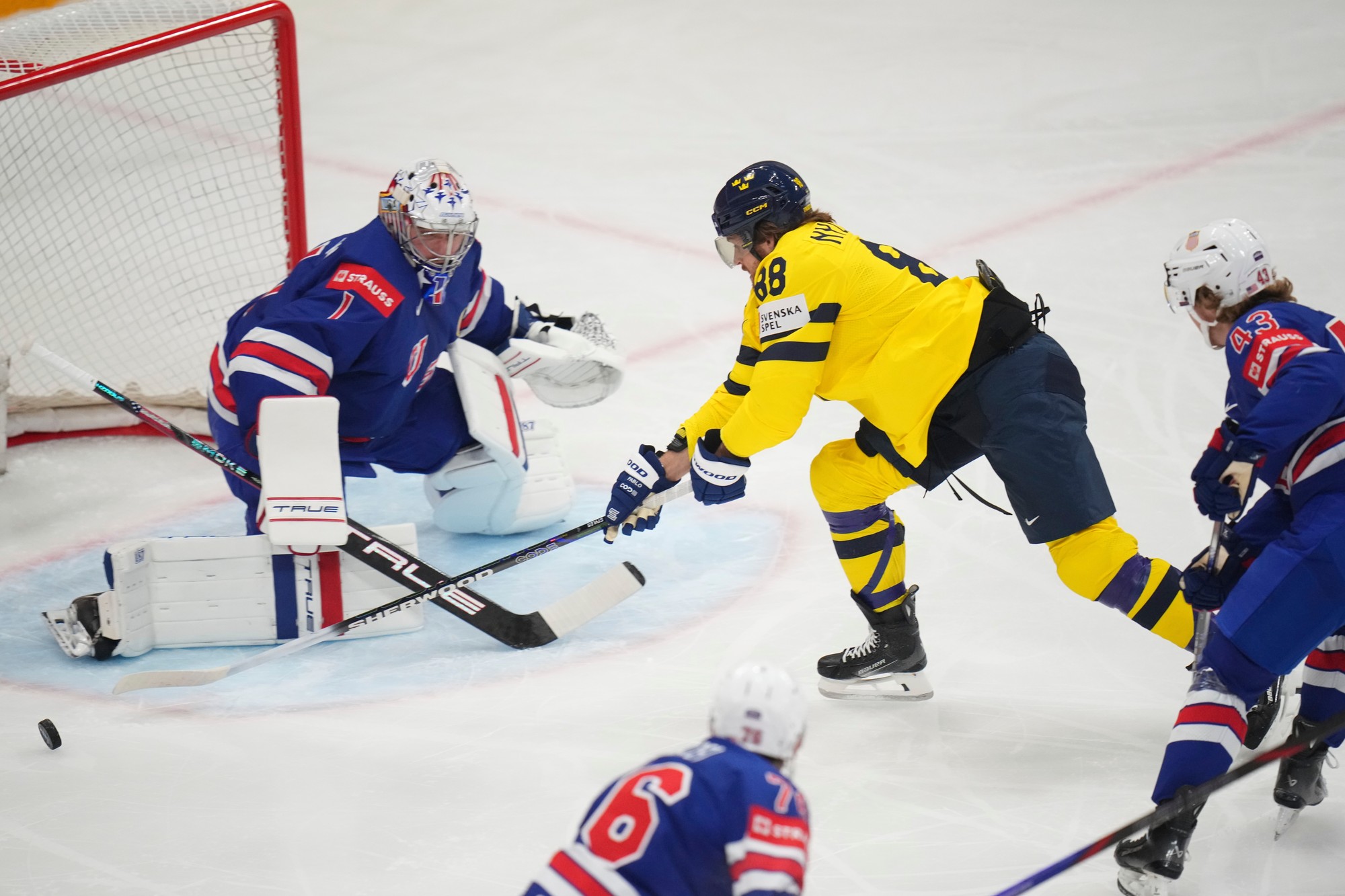 Švédsky hráč William Nylander(uprostred) sa pokúša strieľať cez amerického brankára Jeremyho Swaymana.