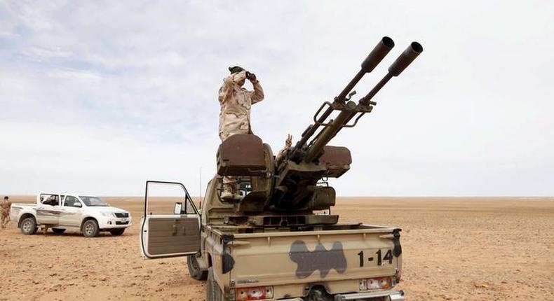 A Libyan soldier looks through binoculars at Wadi Bey, where troops are manning outposts, west of the Islamic State-controlled city of Sirte, February 23, 2016. REUTERS/Ismail Zitouny