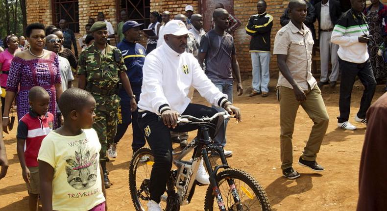 President Pierre Nkurunziza rides a bicycle as he heads to the venue where he voted in at a polling station in his rural home in Ngozi during a parliamentary election in Burundi June 29, 2015. REUTERS/Stringer