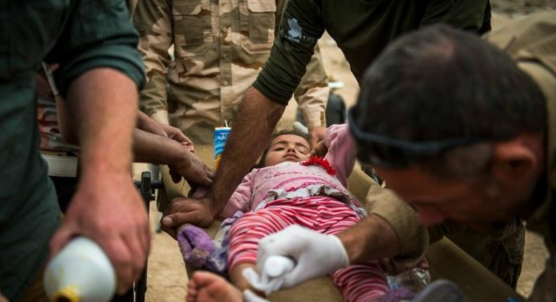 Front line medics from the Iraqi Special Forces 2nd division and volunteers from the Slovak charity Academy of Emergency Medicine treat an Iraqi girl with a shrapnel wound in the Samah neighbourhood of Mosul on November 15, 2016