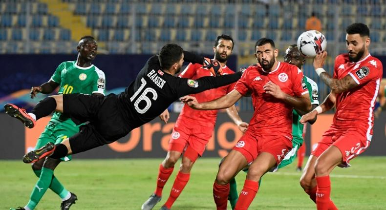 Dylan Bronn (R) of Tunisia concedes the own goal that gave Senegal victory in an Africa Cup of Nations semi-final in Cairo