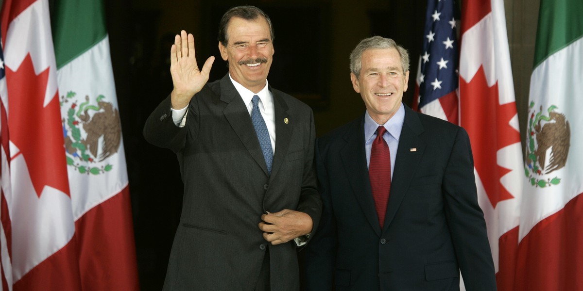 Mexican President Vicente Fox, left, waves as he is welcomed by US President George W. Bush at Baylor University in Waco, Texas, March 23, 2005.