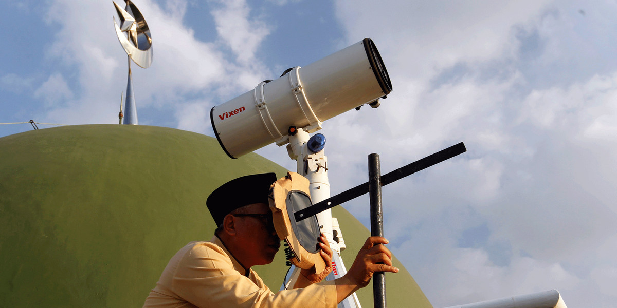 A Muslim man using a traditional tool to look at the position of the moon near the end of the holy fasting month of Ramadan at Al-Musyari'in mosque in Jakarta, Indonesia.
