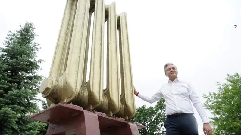 Robert Biedroń pod pomnikiem grzejnika w Stąporkowie