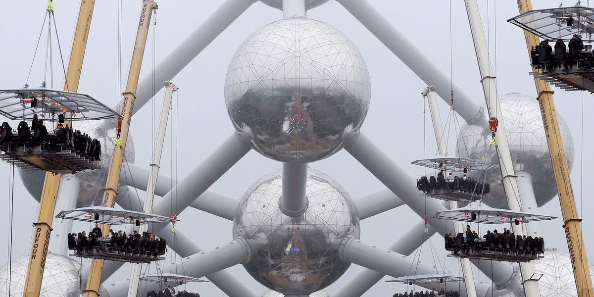 Guests at tables suspended from cranes at a height of 131 feet in front of the Atomium, a 335-foot-high structure and its nine spheres, built for the 1958 Brussels World's Fair, as part of the 10th anniversary of the event known as "Dinner in the Sky" in Brussels.