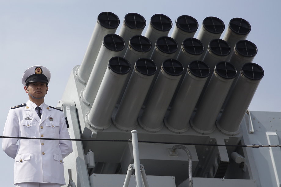 A Chinese People's Liberation Army Navy personnel stands on the deck of a Chinese naval guided missile destroyer.
