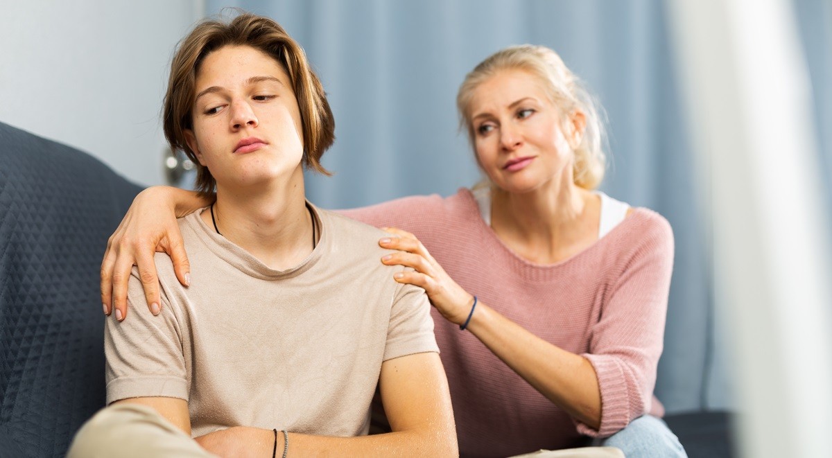 Rodzic wspierający swoje dziecko, obejmuje je za ramiona