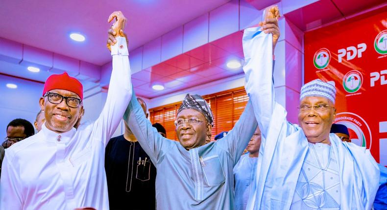 PDP National Chairman, Iyorchia Ayu (middle) raises the hands of former Vice President, Atiku Abubakar (right) and Governor Ifeanyi Okowa (left) as President and Vice Presidential candidates of the party. (Delta State Govt)