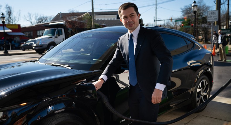 DOT Secretary Pete Buttigieg charges an electric car.