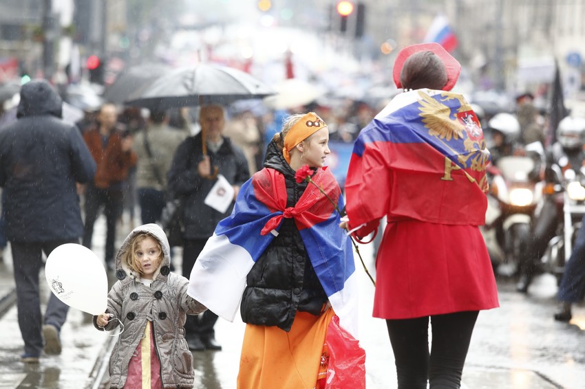 Majka sa decom koja nose i ruske i srpske zastave