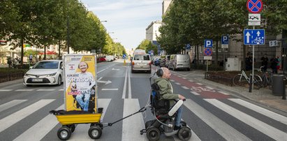 Wybory 2023. Łukasz Krasoń ciągnie po Warszawie swój baner wózkiem elektrycznym. Po co idzie do polityki?