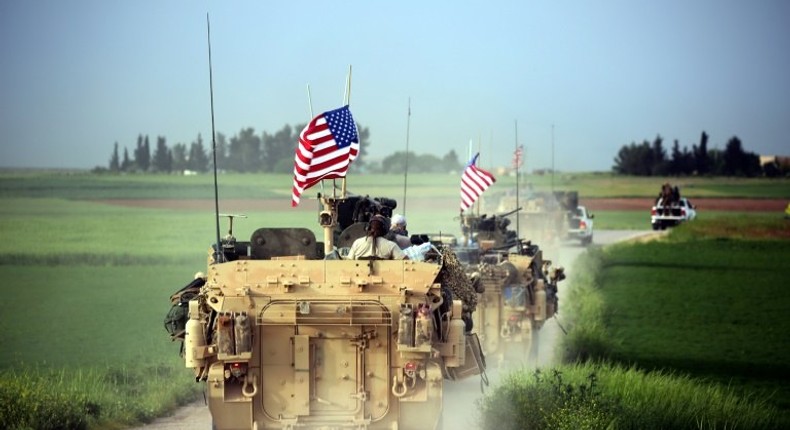 US forces accompanied by Kurdish People's Protection Units fighters (YPG) drive their armoured vehicles on April 28, 2017, near the village of Darbasiyah, Syria