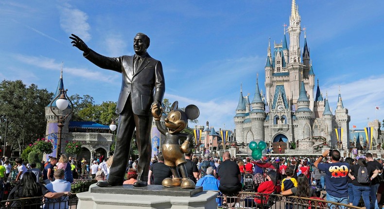 In this January 9, 2019, photo, guests watch a show near a statue of Walt Disney and Micky Mouse in front of the Cinderella Castle at the Magic Kingdom at Walt Disney World in Lake Buena Vista, part of the Orlando area in Florida.John Raoux, File/AP Photo