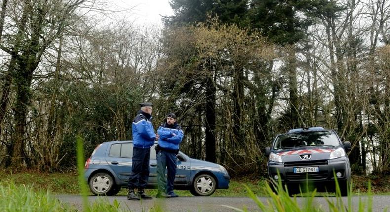 French gendarm block the access to a road, where a healthcare card in the name of Charlotte Troadec has been discovered by a runner on March 1, 2017, in Dirinon, some 20 km east of Brest, western of France